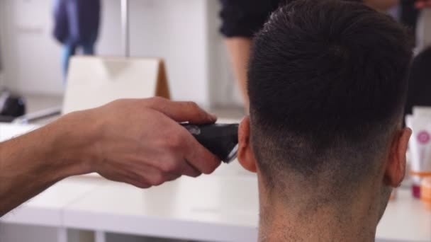 Close-up van een kapper handen maken van een mannelijke machine kapsel — Stockvideo