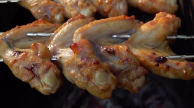 Şişlerin üzerinde salamura edilmiş tavuk kanadı manzarası.