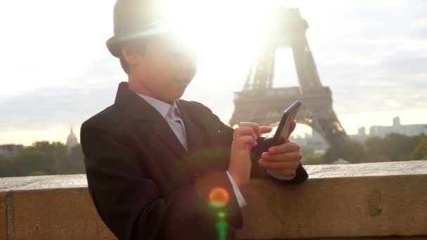Un ragazzo carino adolescente con un cappello grigio sta facendo clic sullo schermo del telefono — Video Stock