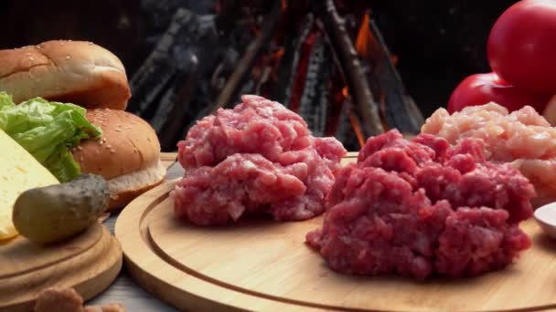 Rohes Hackfleisch von Huhn, Rind und Schwein auf dem Hintergrund eines offenen Feuers — Stockvideo