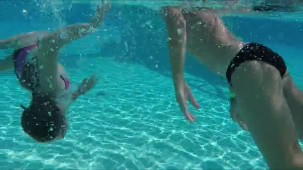 Fröhliche Kinder tauchen im Becken unter Wasser — Stockvideo