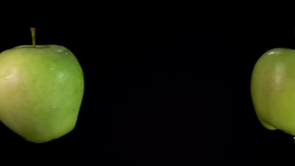 Primo piano di due mele verdi che si scontrano e spruzzano gocce d'acqua — Video Stock