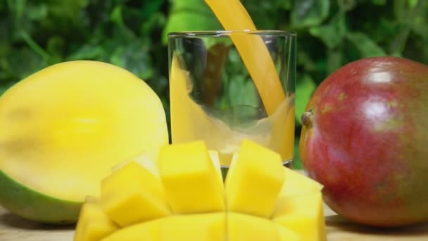 Mango šťáva se nalévá ve sklenici na zeleném pozadí — Stock video