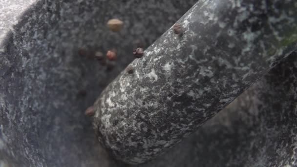Piccanti grani di pepe nero stanno cadendo nella malta di pietra grigia — Video Stock