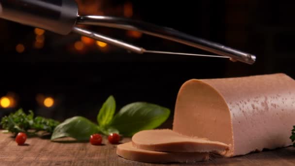 Un cuchillo de cuerda especial está cortando deliciosos foie gras franceses en una tabla de madera — Vídeo de stock