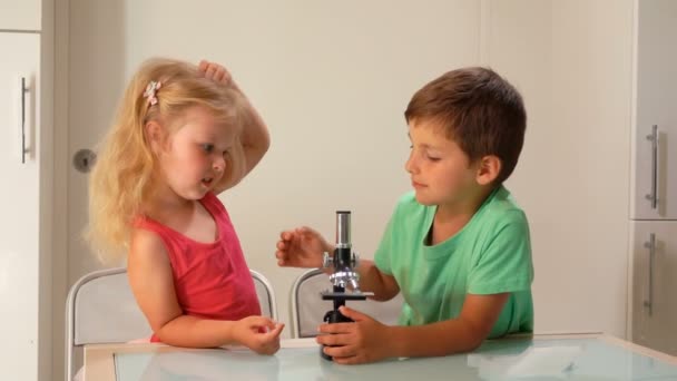 Piękne dzieci zachwycają się obrazem w soczewce mikroskopu — Wideo stockowe