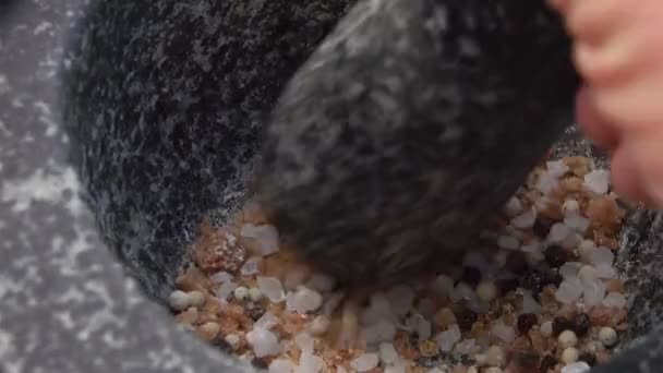 Primer plano de molienda y mezcla de sal y pimientos en el mortero de piedra gris — Vídeos de Stock