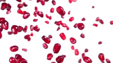  Kırmızı sulu olgun nar taneleri beyaz arka plana düşüyor.