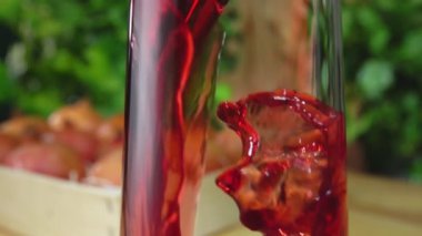 Arka plandaki bir sürahiye akan nar suyunu yakından çek.