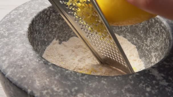 Primo piano della griglia di limone sulla grattugia nella malta di pietra — Video Stock