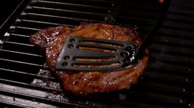 Lezzetli et bifteği ızgaranın sıcak yüzeyine bastırılır.