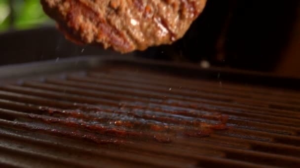 Deliciosa carne hamburguesa chuleta se voltea en la superficie caliente de la parrilla — Vídeo de stock