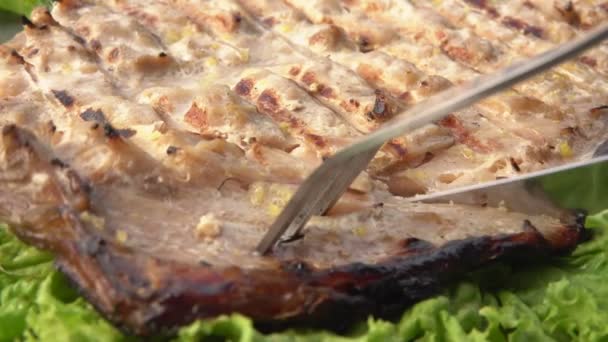 Un coltello e una forchetta stanno prendendo un pezzo di delizioso pesce bianco grigliato Sgombro — Video Stock