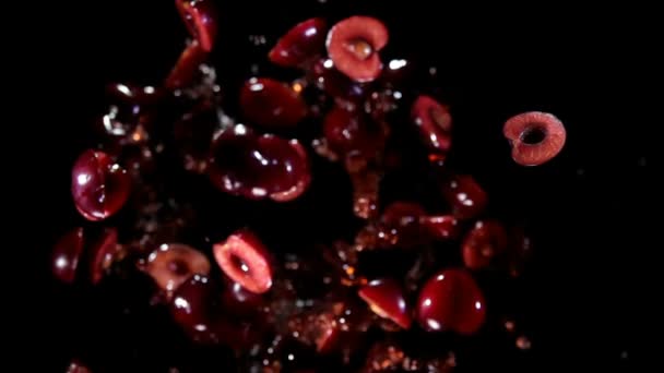 Vista superior de las mitades de cereza roja oscura rebotando con salpicaduras de jugo — Vídeo de stock