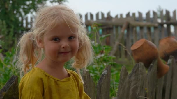 Okouzlující blond farma dívka stojící v blízkosti dřevěné vesnice plot — Stock video