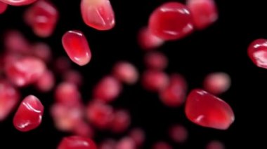 Siyah zemin üzerinde zıplayan kırmızı nar taneciklerinin süper yakın çekimi