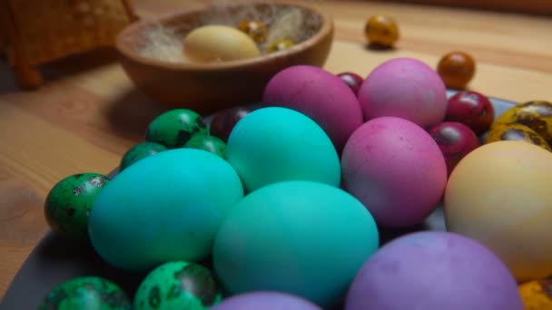Panorama de huevos de Pascua multicolores en el plato gris en la mesa de madera — Vídeos de Stock
