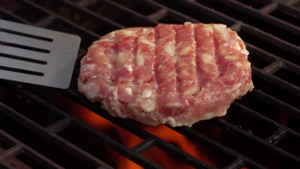 Roh-Fleisch-Burger-Schnitzel mit Zwiebeln wird mit Küchenspachtel auf dem Grill umgedreht — Stockvideo
