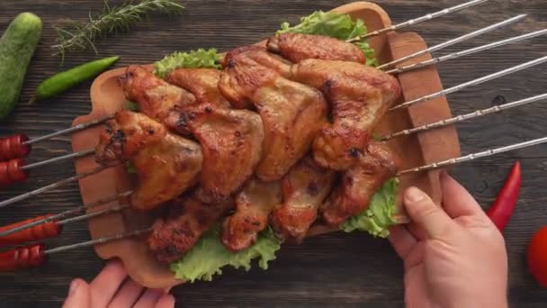 Vista superior de las manos masculinas colocando un plato lleno de deliciosas alitas de pollo frito — Vídeos de Stock