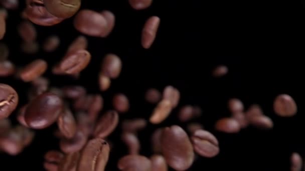 Свіжообсмажені кавові зерна літають вниз і обертаються — стокове відео