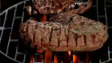 İki lezzetli biftek ızgarada kızarıyor.