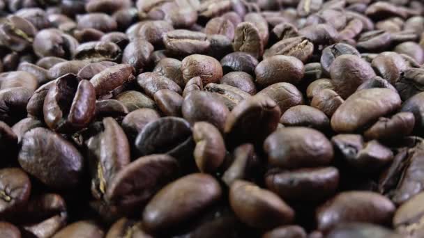 갈색 커피 텍스처 위로 떨어지는 볶은 커피 원두의 근접 사진 — 비디오