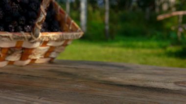 Böğürtlenler ahşap masadaki huş ağacından dökülüyor.