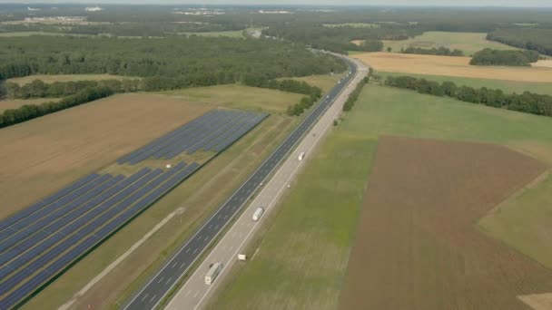 Tiro aéreo de um complexo futurista de painéis solares perto da estrada — Vídeo de Stock