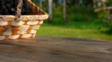 Böğürtlenlerin ahşap masadaki huş sepetinden düşüşü. 