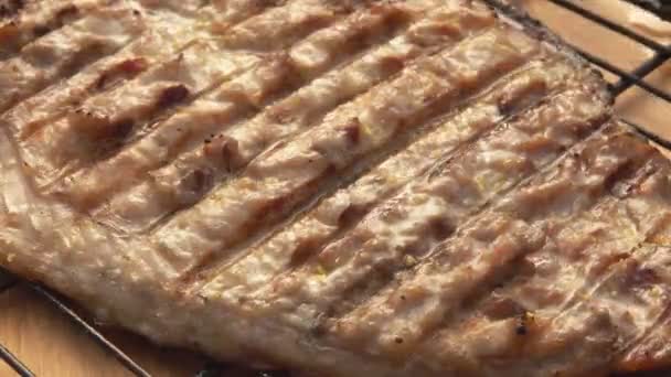 Barbeque grill grid dengan ikan Mackerel putih di latar belakang meja kayu — Stok Video