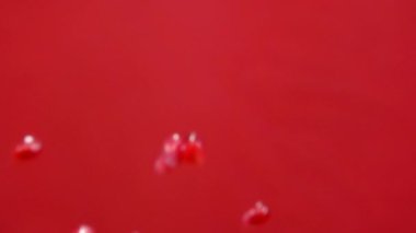 Kırmızı arka planda olgun nar taneleri zıplıyor.