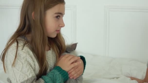 Das fröhliche langhaarige Mädchen im Strickkleid umarmt ein niedliches Kaninchen — Stockvideo
