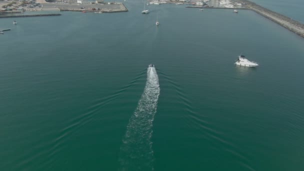 Tiro aéreo de uma lancha que atinge uma baía de marina no Mar Mediterrâneo — Vídeo de Stock