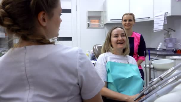 O dentista e a paciente relaxada estão falando sobre a questão dentária. — Vídeo de Stock