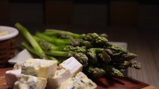 Panorama des ingrédients pour sauce au fromage sur une planche sur fond d'asperges — Video