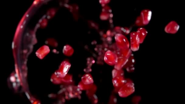 Grãos de romã brilhantes estão saltando com salpicos de suco vermelho — Vídeo de Stock