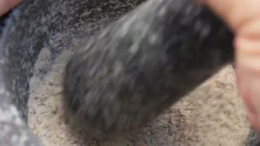Taş tokmağının süper yakın çekimi gri havanda baharat karıştırıyor.