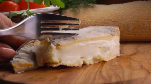 Un tenedor toma un pedazo de queso francés suave y cremoso Epoisses en el molde marrón — Vídeos de Stock