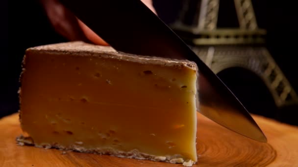Nóż tnie cienki plasterek pysznego twardego sera na drewnianej desce — Wideo stockowe