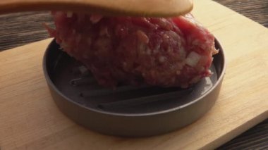 Hamburger pirzolası için kalıba soğan sıkıştırılmış çiğ et yakın plan.
