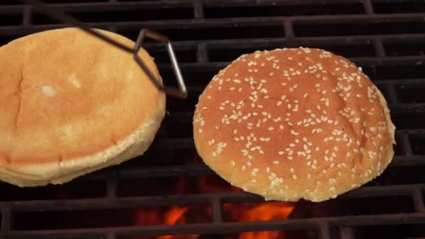 Primo piano dei panini di hamburger freschi con semi di sesamo bianco che friggono sulla griglia — Video Stock