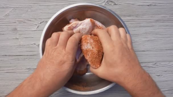 Vista superior das mãos masculinas misturando asas de frango com especiarias na tigela — Vídeo de Stock