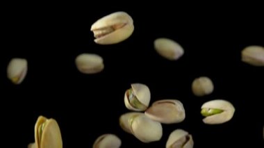 Siyah arka planda uçan tuzlu şam fıstıklarının yakın çekimi