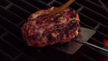 Lezzetli ev yapımı et burger pirzolası ızgarada kızarıyor.