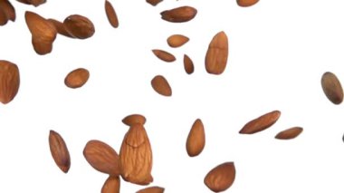 Close-up of delicious almonds flying on a white background