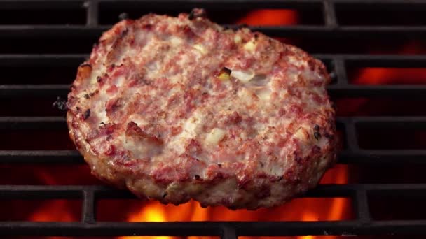 Close-up de uma costeleta de hambúrguer caseira feita de carne e cebolas assando em uma grelha — Vídeo de Stock