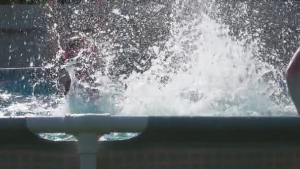 Twee kleine meisjes spetteren water in een zwembad in de achtertuin buiten — Stockvideo
