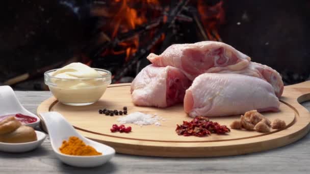 Ateşin arka planında ızgara tavuk bacağı hazırlamak için gerekli malzemeler. — Stok video