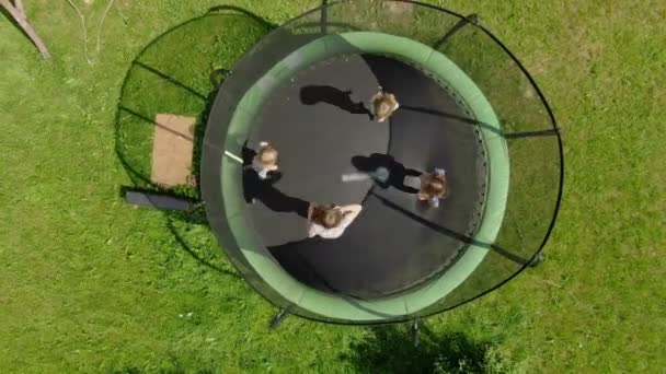 Aerial shooting of a little girls company jumping and running on the trampoline — Stock Video