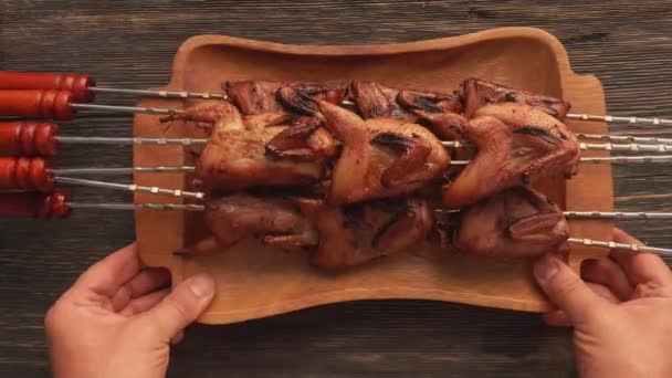 Vista superior de deliciosas codornices a la parrilla en el plato de madera colocado sobre la mesa — Vídeo de stock